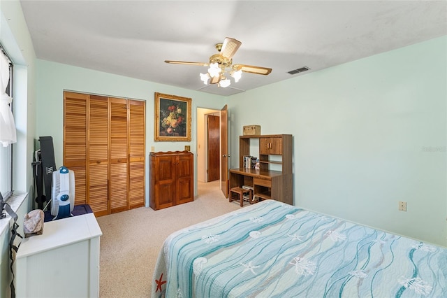 bedroom featuring ceiling fan, a closet, visible vents, and light colored carpet