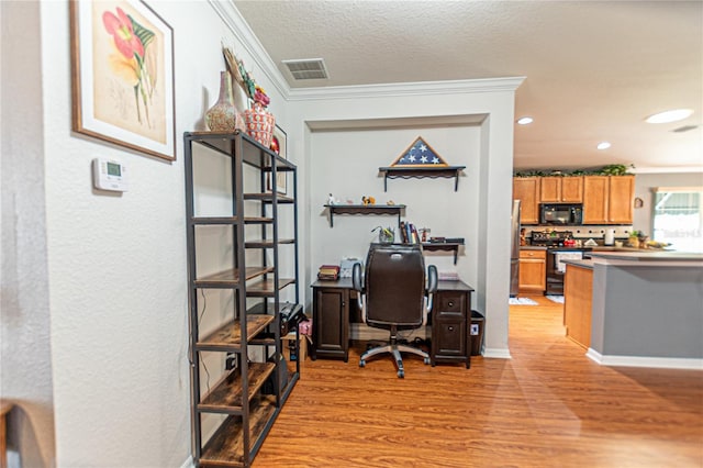 office area with a textured ceiling, ornamental molding, and light hardwood / wood-style flooring