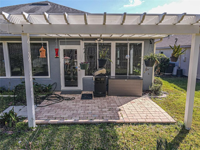 entrance to property with a patio, a pergola, and a lawn