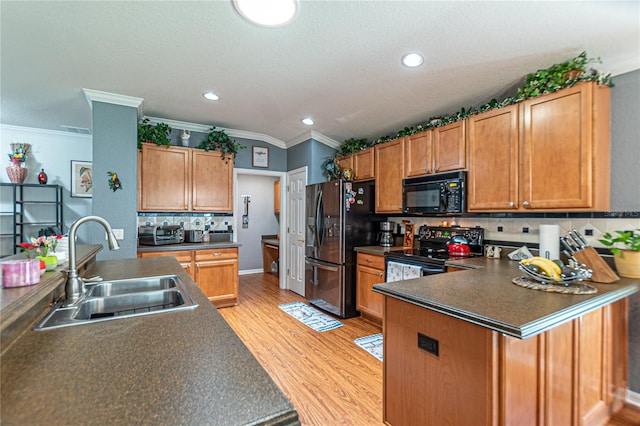 kitchen featuring sink, backsplash, light hardwood / wood-style floors, black appliances, and ornamental molding