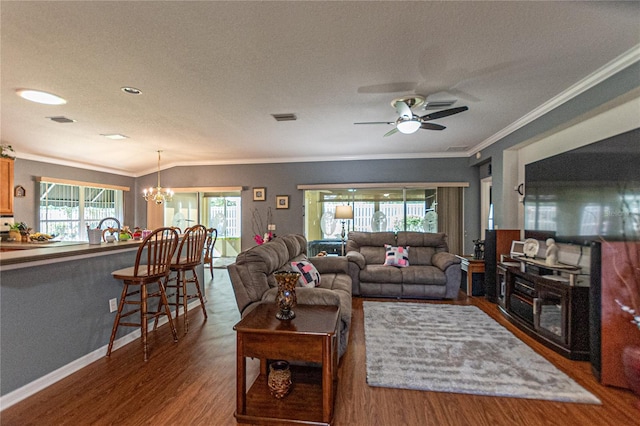 living room featuring ceiling fan with notable chandelier, ornamental molding, dark wood-type flooring, and a textured ceiling