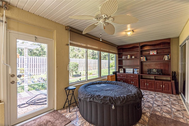 interior space with ceiling fan, wooden ceiling, and a healthy amount of sunlight