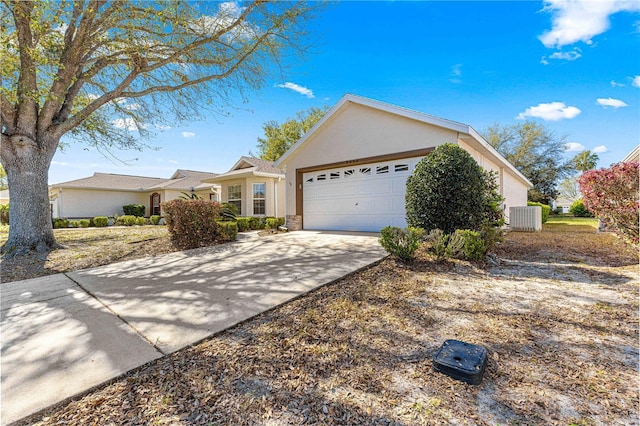 single story home featuring central AC unit, stucco siding, driveway, and a garage