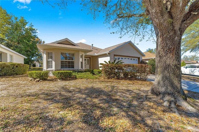 ranch-style house with a garage and stucco siding