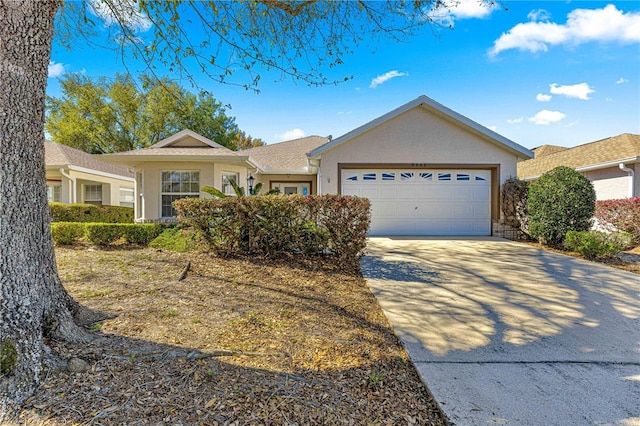 ranch-style home with stucco siding, an attached garage, and driveway