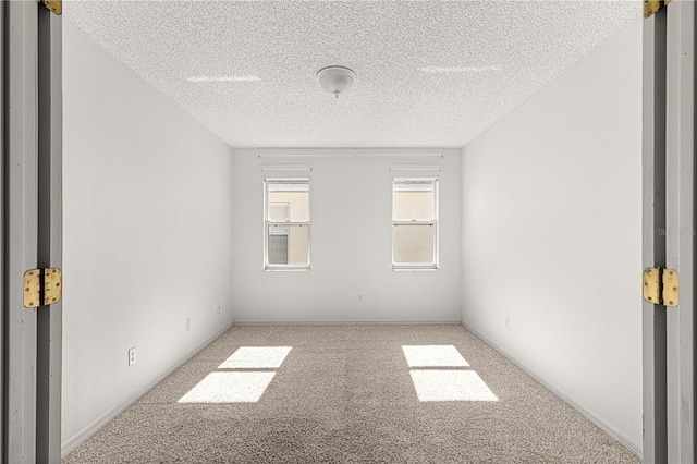 carpeted empty room featuring a textured ceiling