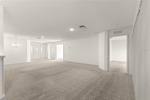 carpeted spare room featuring baseboards, recessed lighting, visible vents, and a textured ceiling