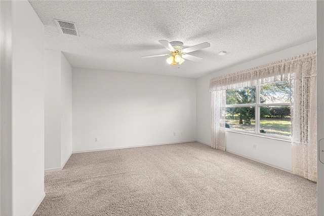 carpeted empty room with visible vents, baseboards, a textured ceiling, and a ceiling fan