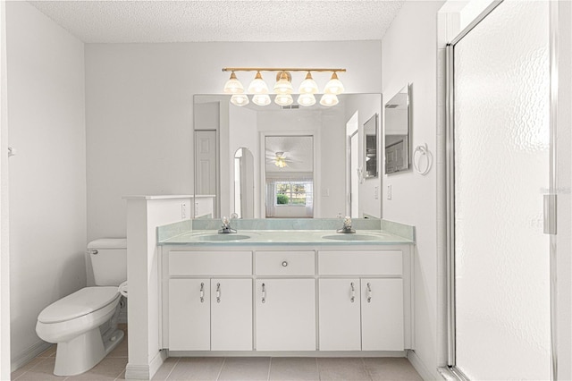 full bathroom with a sink, toilet, double vanity, and a textured ceiling