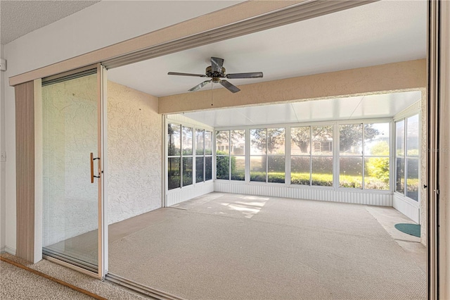 unfurnished sunroom featuring a ceiling fan