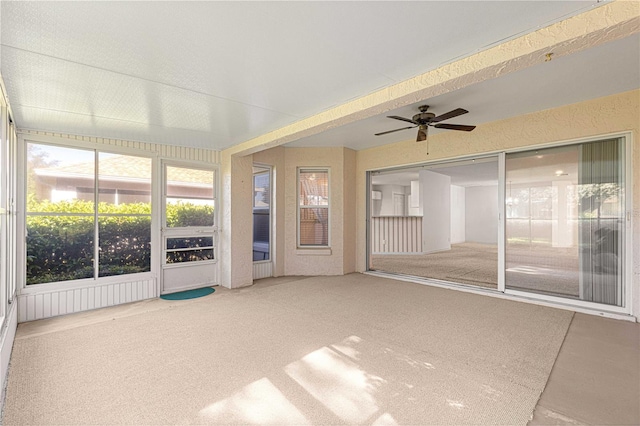 unfurnished sunroom with ceiling fan