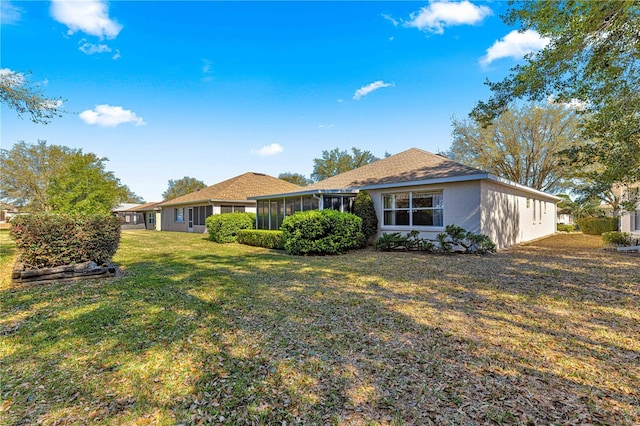 rear view of property featuring a yard and a sunroom