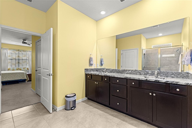 bathroom with walk in shower, vanity, and tile patterned flooring