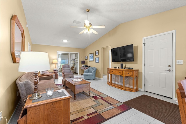 tiled living room with a textured ceiling, vaulted ceiling, and ceiling fan