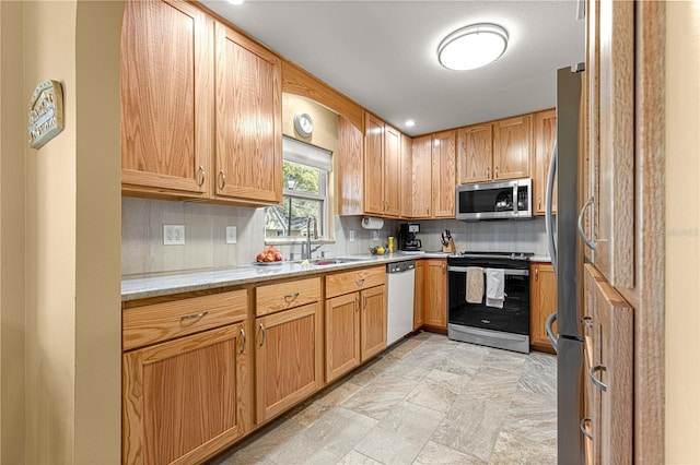 kitchen featuring decorative backsplash, stainless steel appliances, light stone countertops, and sink