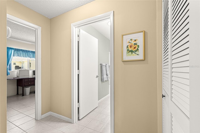 hallway with light tile patterned flooring and a textured ceiling