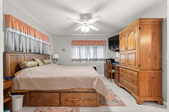 bedroom with ceiling fan, built in desk, and a textured ceiling