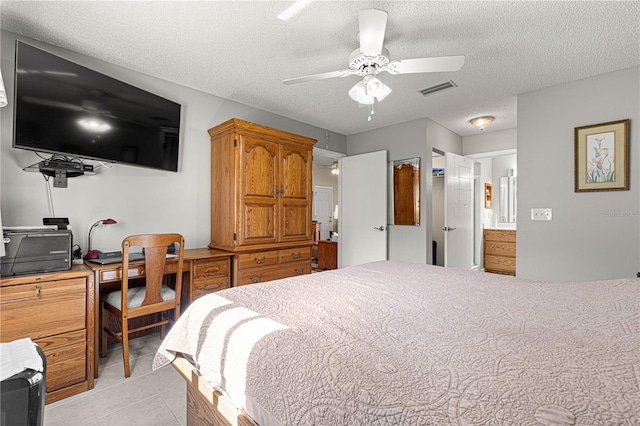 bedroom featuring a textured ceiling, ensuite bathroom, ceiling fan, and light tile patterned floors