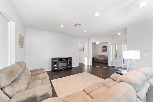 living room featuring ceiling fan and dark hardwood / wood-style floors