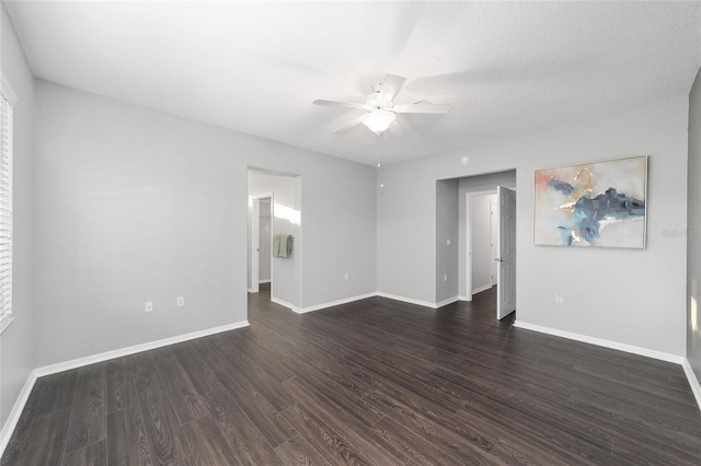 empty room featuring dark wood-type flooring and ceiling fan