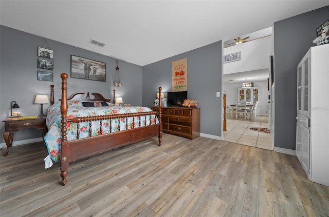 bedroom featuring baseboards, visible vents, and light wood finished floors