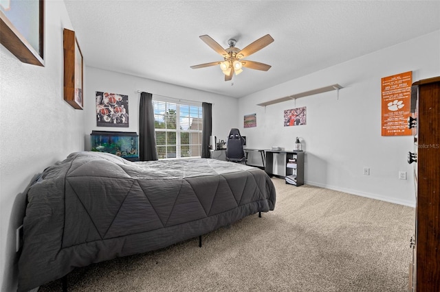 carpeted bedroom featuring ceiling fan, baseboards, and a textured ceiling