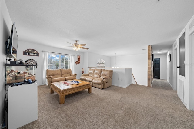 living room featuring ceiling fan with notable chandelier, a textured ceiling, and light colored carpet