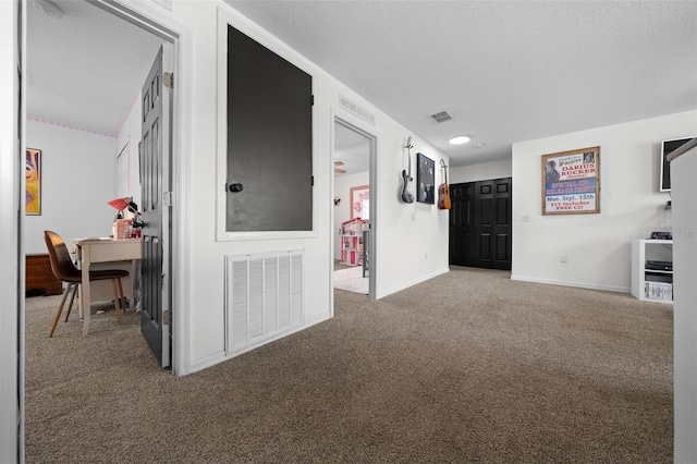 spare room with baseboards, a textured ceiling, visible vents, and carpet flooring