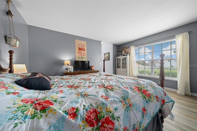 bedroom with light wood finished floors and baseboards