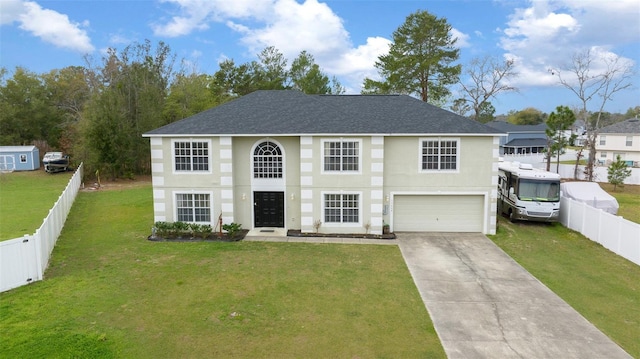 view of front of home featuring driveway, an attached garage, fence, and a front yard