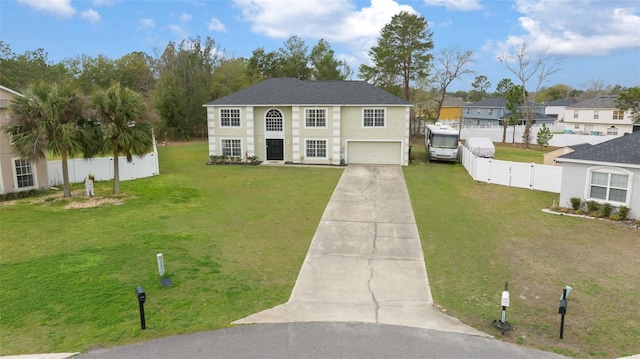 view of front facade with driveway, a garage, fence, a front yard, and stucco siding