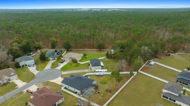 drone / aerial view featuring a forest view and a residential view