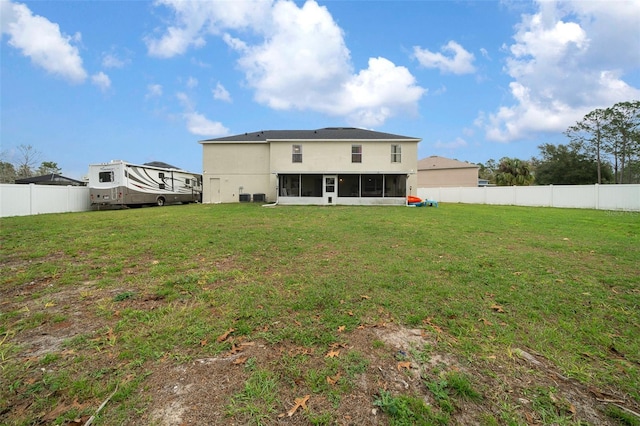 rear view of property with a sunroom, a fenced backyard, and a yard