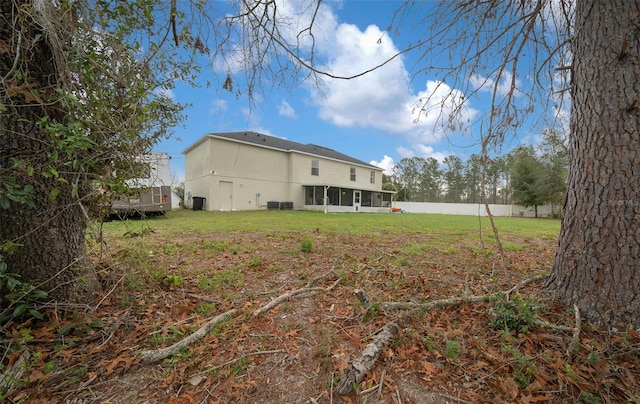 back of house featuring a lawn and fence