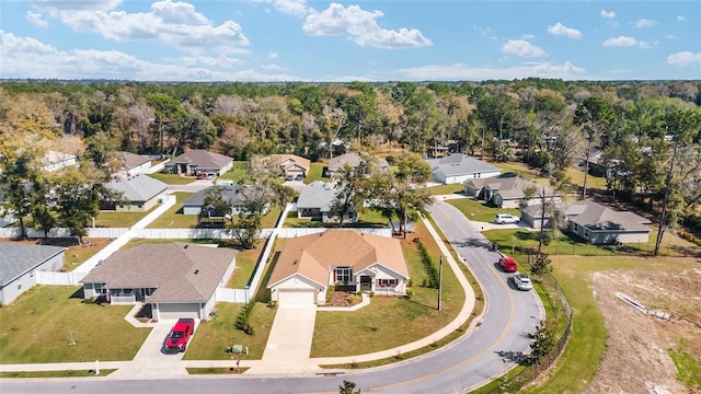 drone / aerial view featuring a residential view and a forest view