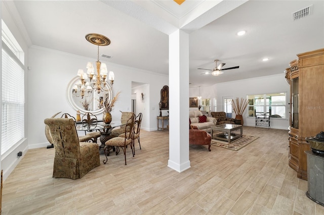 dining room with ornamental molding, visible vents, light wood-style floors, and ceiling fan with notable chandelier