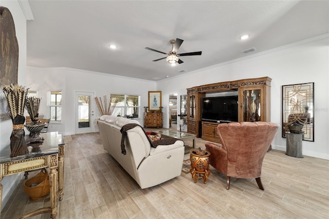 living room with baseboards, visible vents, a ceiling fan, ornamental molding, and light wood-type flooring