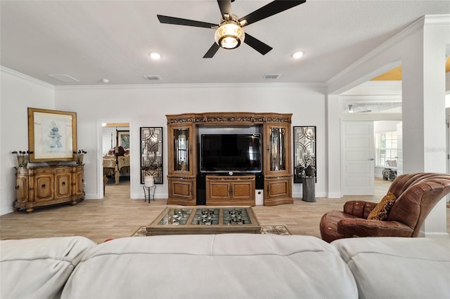 living area with light wood-style floors, visible vents, and crown molding