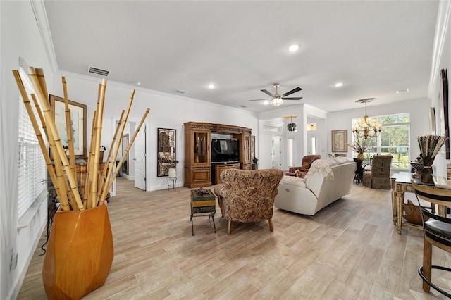 living room with light wood-type flooring, ornamental molding, and ceiling fan with notable chandelier