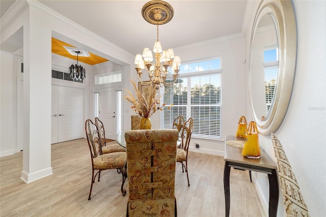 dining area with light wood-type flooring, baseboards, ornamental molding, and a notable chandelier