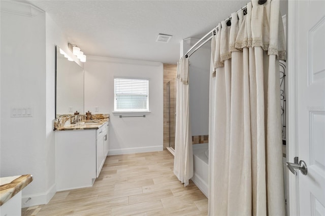 full bath featuring curtained shower, visible vents, a textured ceiling, vanity, and wood finished floors