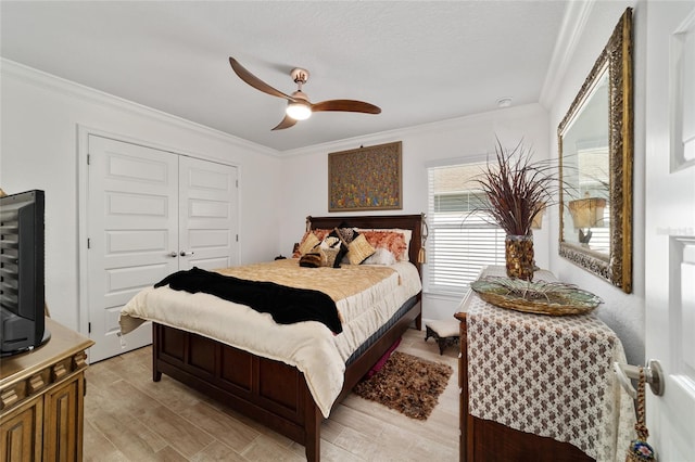 bedroom featuring light wood-style flooring, ornamental molding, and a closet