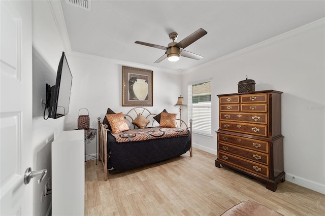 bedroom with light wood finished floors, visible vents, ornamental molding, and baseboards