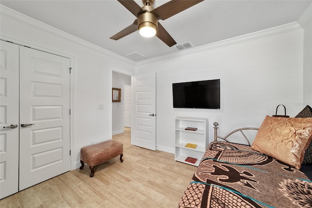 bedroom with light wood-style floors, visible vents, crown molding, and a ceiling fan