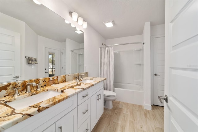 bathroom featuring toilet, shower / tub combo, a sink, and wood finished floors