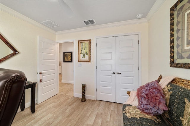 office space with crown molding, baseboards, visible vents, and light wood-style floors