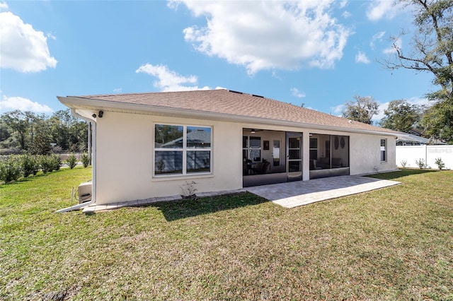 back of property featuring a sunroom, a lawn, and stucco siding