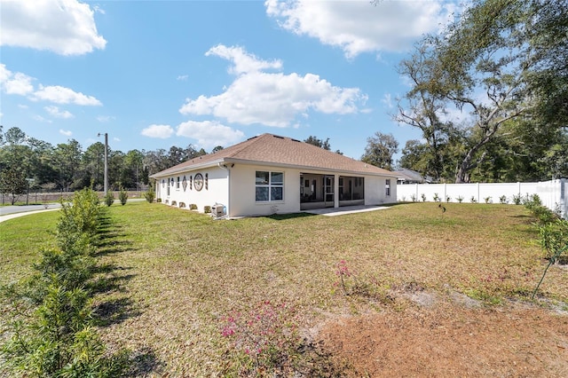 back of property with a lawn, a patio area, a fenced backyard, and stucco siding