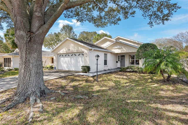 ranch-style home with driveway, a front yard, a garage, and brick siding