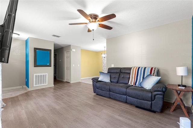 living room with light wood-type flooring and ceiling fan